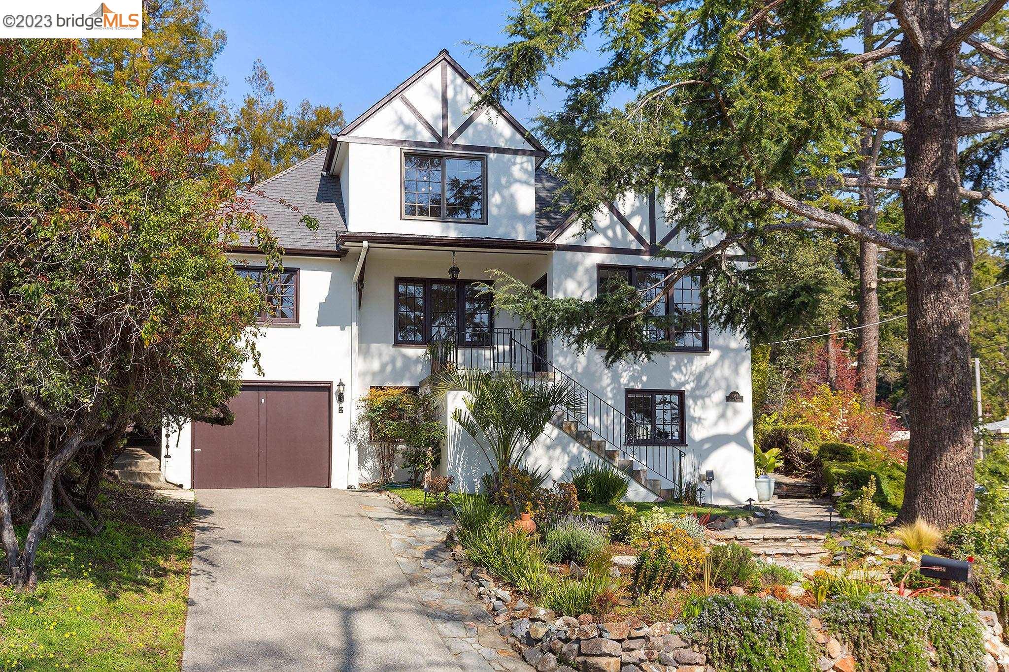 Set in the lower Berkeley Hills, this storybook Tudor has been extensively renovated with stylish finishes and sophisticated colors throughout. Vaulted ceilings and open floor plan combine dining and living areas with warm hardwood floors. Kitchen and bathrooms were recently remodeled with fashionable tiles, new fixtures and appliances. Two generous and light filled bedrooms on the entry level floor share a common bath while the upper floor consists of a cozy primary retreat with large closets and utmost privacy. Downstairs, a family room with additional bedroom and bath creates a cozy lounge space, guest quarters or au-pair with separate entrance. In back, a private seating area and rear yard are perfect for entertaining. The one-car garage and spacious driveway offer ample parking space. Located in close proximity to transportation, parks, schools and the SF commute.
