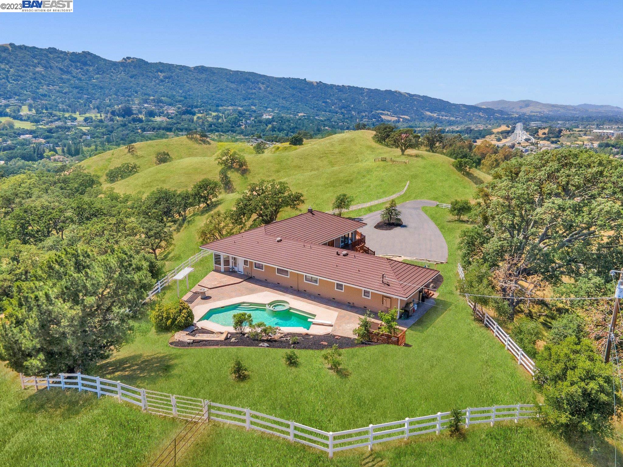 Amazing opportunity to live like you’re on top of the world! Secluded 3455 sqft home nestled on top of 43 acres of rolling hills in Pleasanton. Captivating 360* views of Tri-Valley. Thoughtfully designed one level floor plan with 4 BD / 2 BA , 2- 1/2 baths, great room with fireplace, formal dining room, game room, office space, and large laundry room, over a 3 car garage. The gourmet kitchen has granite countertops, Wolf appliances, and walk-in pantry.  Plenty of space for entertaining family or friends. Whether you’re out front on the wrap around deck, inside, or in the beautiful backyard oasis with sparkling pool and waterfall. There are 2 large workshops totaling 3500 sqft and a 7 stall barn along the private driveway with electric security gate. Easy access to 680 freeway, and a short commute to Silicon Valley. Minutes to award winning schools and charming downtown with great restaurants and shopping. Close to Livermore wineries and less than 1 mile to Callippe Preserve Golf Course. This property is truly one of a kind that you won’t want to miss!!