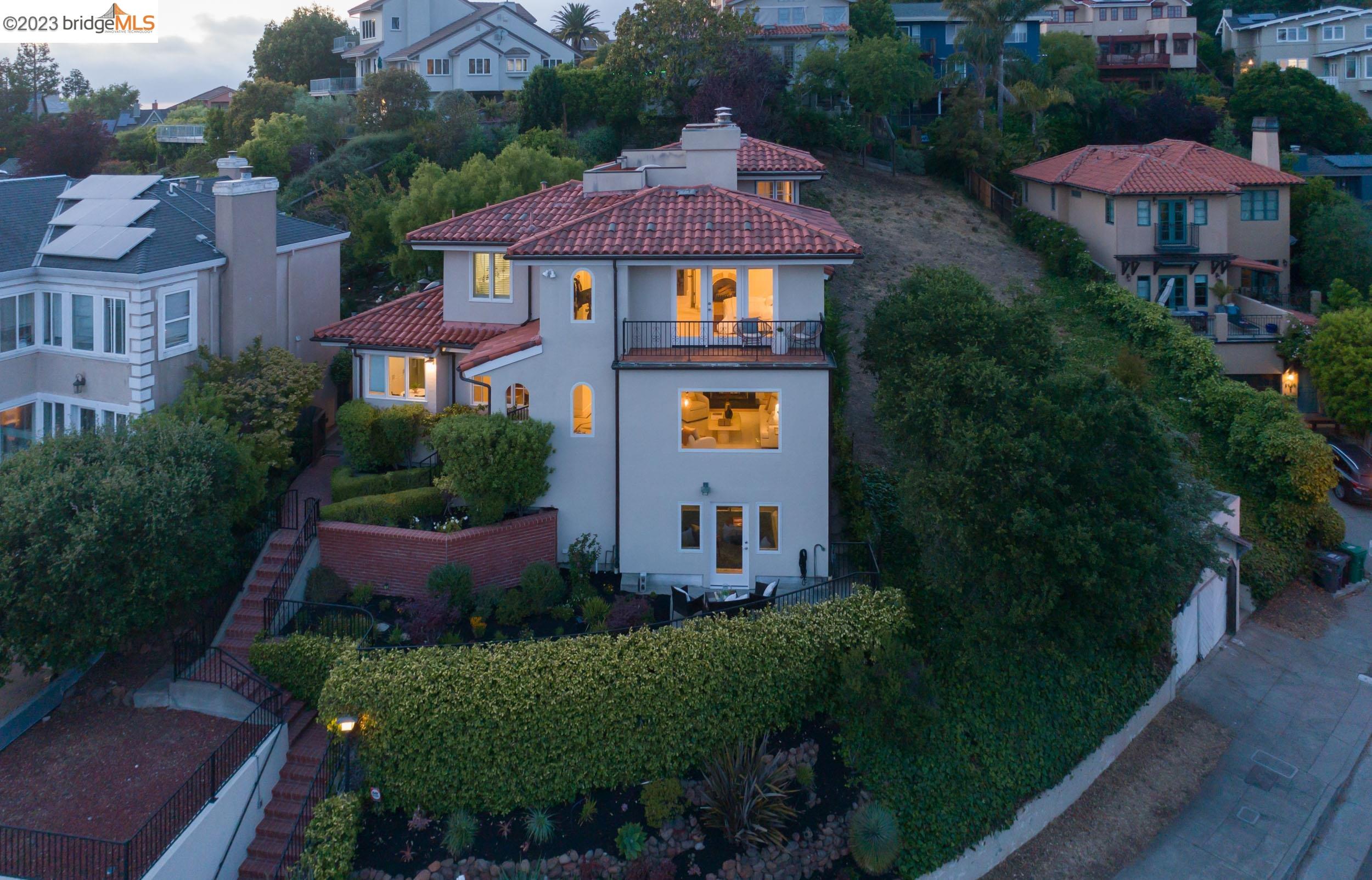 Located in desirable Upper Rockridge, this 4+ bedroom, 3 bath mediterranean is sure to impress with its comfortable style. Enter to natural light, architectural archways and open spaces. The ample living room with fireplace has a large picture window overlooking serene bay views. The kitchen opens to the formal living room which leads to a large back yard - perfect for indoor/outdoor entertaining. With multiple places to relax, garden and play, this outdoor oasis has room for everyone. 2 ample bedrooms and full bath complete this level.  Upstairs, the primary suite with fireplace, balcony and large bathroom is a dream. Don't miss the opportunity to add a sauna to an already designated space. A large, open loft space overlooks the back yard and creates opportunity for play room, home office or guest suite. Downstairs, a large studio suite opens to a private patio via French doors.  Location, light and comfortable style combine to make 5964 Buena Vista the perfect place to call home.