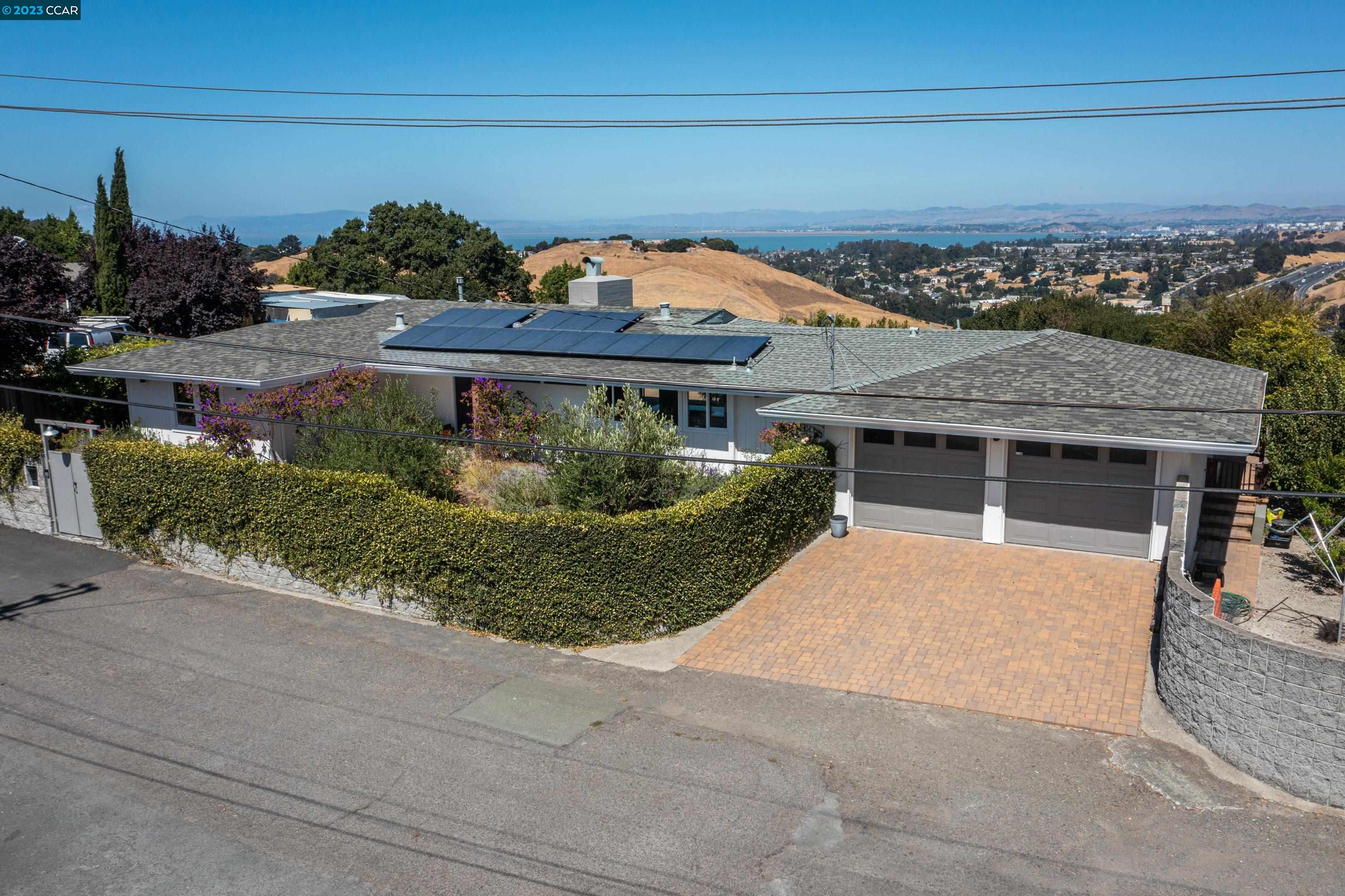 Single story, indoor/outdoor living in this showcase home atop a ridge with expansive views of shimmering San Pablo Bay. Built to take full advantage of the location, almost every room opens to panoramic view & a huge patio runs across the back of house down to large pool & abundant kitchen garden. The ocean fog that often lingers over the west face of the Berkeley hills breaks up as it crests this mountain range but not before adding precious moisture to the air. The mix of added moisture & longer hours of sunlight means plants thrive, the heat is tempered, & the 22 solar panels soak up the savings. As you enter the compound & walk through the drought tolerant meadow of flowers, grasses & olive trees, the home’s ‘secret garden’ welcomes you with serenity & calm. A graceful entry to breathtaking views, bright open floorplan with many upgrades & lovingly cared for mid-century features. Airy kitchen boasts garden views from the sink & bay views from the range. Interior access to spacious laundry-mudroom provides separation for a fourth bedroom with ensuite bath – perfect for in-law/au pair or potential ADU. Fully usable ½ acre lot includes side yard with fruit trees & enough space for RV/boat. The location affords easy freeway access within a secluded neighborhood.