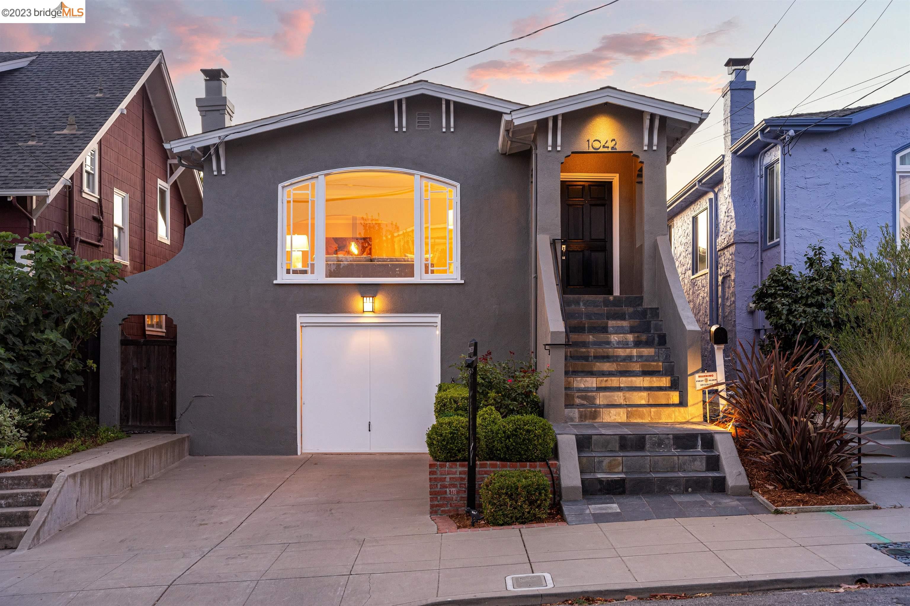 Nestled in Albany's coveted Terrace Park neighborhood, this 3-bed, 2-bath craftsman bungalow offers elegant living near Marin Elementary School, BART, parks, and Gilman and Solano Ave. shops and restaurants. Craftsmanship shines from the slate tile stairwell to the formal living room with an expansive east-facing window, inviting ample natural light. A black slate fireplace and arched entryway lead to a spacious formal dining room. Two bedrooms and a tastefully tiled bathroom lie down the main hallway, one with attic access. The bright kitchen boasts white cabinetry, Corian countertops, and custom tile flooring extending into the rear stairwell. Descending, find a primary suite with high ceilings, a small log fireplace, walk-in closet, and a custom-tiled en-suite bathroom. The ground level wows with two-story ceilings and floor-to-ceiling windows opening to the tranquil rear garden, featuring a deck and travertine tile patio—an ideal retreat. The lower level offers a versatile 442 sq.ft. space with 7ft. ceilings, windows, and access to the garage. Refinished hardwood floors, period windows, and moldings add character. The basement houses laundry and storage. This Albany gem offers timeless charm, modern amenities, and a prime location—a rare find.