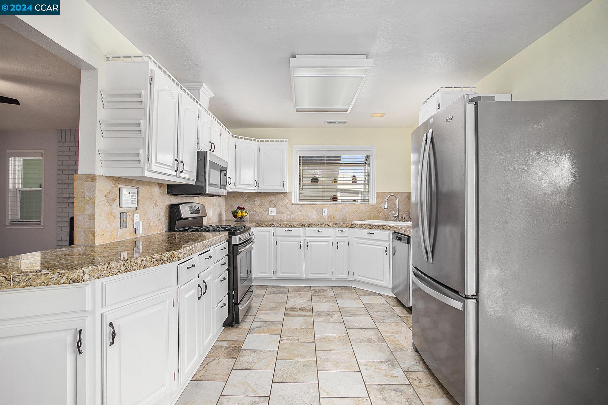 Beautiful stainless appliances, garden window and stone tile countertops.  Plenty of Cabinet space