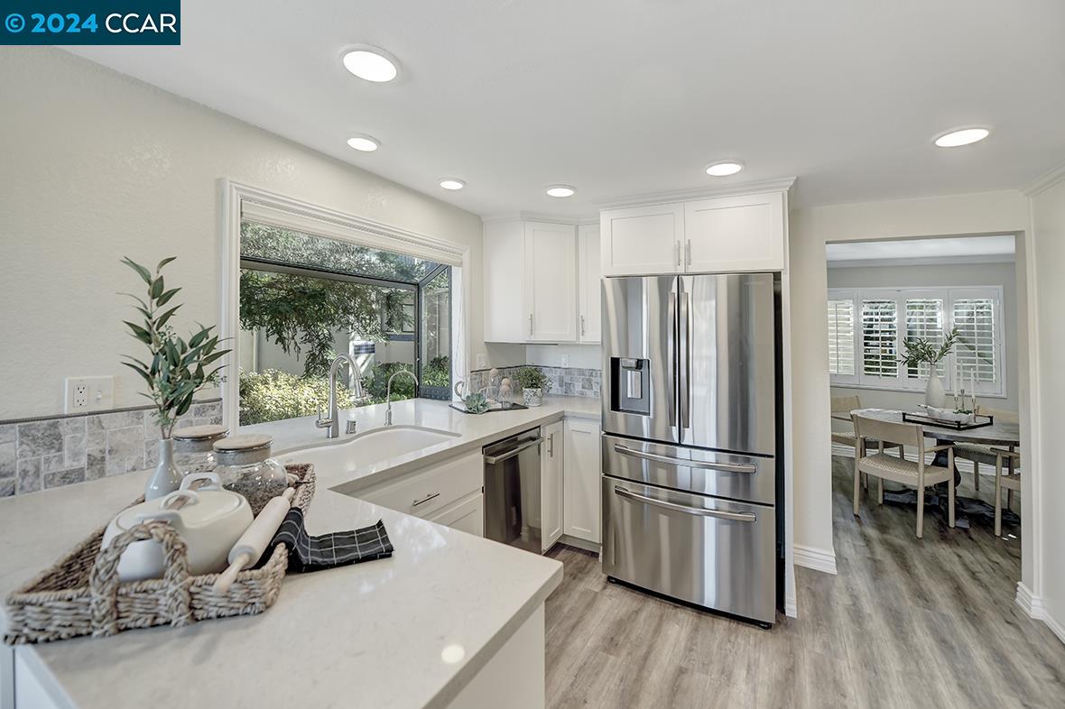 Welcome to this highly desirable, Extensively Remodeled, 2-bedroom, 2-bath Doral model condo, an end unit w/ stunning views of the Rossmoor hills from the kitchen nook. The open floor plan is perfect for entertaining or relaxation. Enjoy your morning coffee on the adjoining deck, soaking in the sunlight, or unwind w/ an evening cocktail as the hills illuminate at sunset. *This home boasts numerous upgrades, incl. two-tone designer paint, crown molding & large baseboards. The kitchen is a chef’s dream w/ quartz counter tops, designer back splash, refaced white cabinets w/pullout, SS appliances & an induction cook top. Add. highlights include updated lighting & plumbing fixtures, a greenhouse kitchen window, a flexible room for formal dining or study & a frame less main shower enclosure. The cozy living room features a wood-burning fireplace. Recent upgrades include a new HVAC system & full-size washer/dryer (2020). Enjoy key less entry, a phantom screen & garage parking!