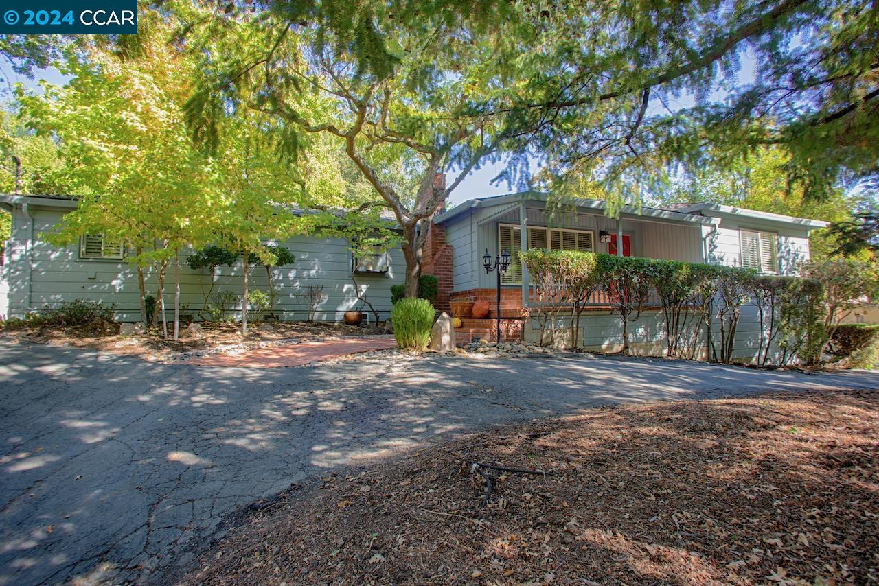 The Santa Cruz mountains meets South Walnut Creek in this beautifully maintained home nestled in the Walnut Heights neighborhood, combining charm and modern amenities. The single story home is perfect for both entertaining and family living. The formal living room welcomes you with its vintage random plank hardwood floors, brick fireplace, and picture window looking out on the covered front porch. The seamless transition to the formal dining room, w/French doors that lead to a back patio, is perfect for gatherings. The eat-in chef’s kitchen is equipped with stainless steel appliances, a breakfast nook, and an over-sized pantry. The family room, with its Terracotta tile floors and gas-burning fireplace opens directly to the backyard, blending indoor and outdoor living. Each of the bedrooms boasts solid oak hardwood floors, ample closet space, and bright, airy windows. Additional highlights: plentiful storage, a picturesque setting with mature trees, a pool, patios and decks, an oversized two-car carport, and a circular driveway.All this is just minutes away from trails, parks, open space, and Walnut Creek downtown shops, restaurants, and theaters. Plus, enjoy the benefits of 12 years of Walnut Creek schools. A perfect blend of tranquility and convenience!