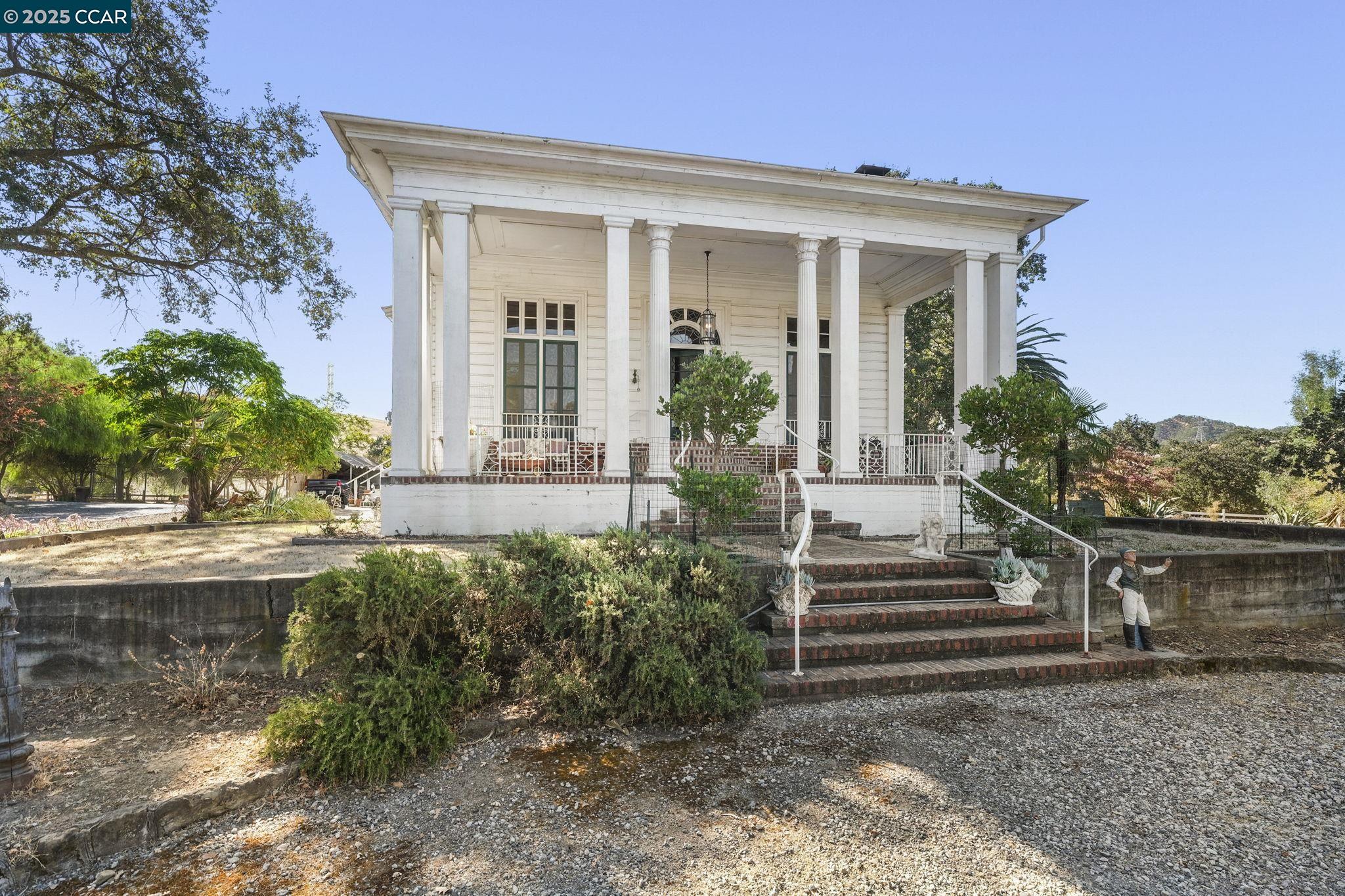 American Colonial era home Built prior to 1907 (1878). A piece of history built by James T. Walker. Down a private lane behind iron gates known as Walker Canyon, Original Walker Ranch at the base of Mt Diablo State Park. Main House ~ 2-story 4700+sqft ceilings12+/-ft throughout. Add'l 2-detached Guest Cottages 1 & 2 bed rms approx. 900sqft ea. Classic Colonial design, featuring a portico & columns that frame a stunning glass entry door. Foyer leads to the formal living rm & library, adorned w/coffered ceilings. Boasting a large brick fireplace, hand-carved wood mantel encompassing the California State Seal, nine grizzly bears adding a touch of historical charm. Library w/floor-to-ceiling bookshelves, cozy sitting area in the bay window. Formal dining rm, soaring ceilings, spacious kitchen via a butler's passage. Kitchen/Breakfast Nook overlook enclosed sun porch & roof deck. Primary suite, sitting area walk-in closet & attached bath. 2-additional bed rms, guest bath. Spiral staircase down to the Family Rm, 4th bed rm 3rd bath, laundry/mud rm w/exterior access to the swimming pool area. For the Equestrian, there is a 7-Stall Barn breeze-way 6-attached paddocks, plus additional separate pastures fenced and cross fenced. 2 Lg axillary buildings/Garages for Cars/RV, etc.