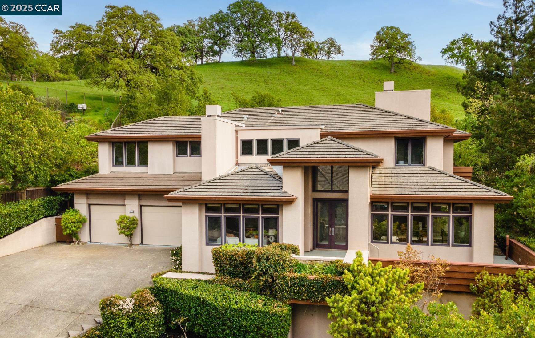Welcome to this exquisite contemporary home in the coveted gated community of Stonegate surrounded by parklands. Each living space in this custom home boasts a designer-like feel, lined with floor to ceiling windows that bring the outdoors in. Views of surrounding nature invites tranquility & provides privacy. 2-story living has never been easier with a full sized elevator. Upon entry, this impressive home showcases an elegant formal dining room & living room. The sleek gourmet kitchen is an entertainer’s dream built with luxurious appliances including SubZero, Franke & Gaggenau. Built for two chefs with with 2 stovetops & griddles, this kitchen also boasts 2 sinks & 2 dishwashers. The spacious dining nook overlooks the backyard & provides access to the outdoor deck with bar & grill for easy al-fresco dining. Venture to the elevated deck with a firepit & 360° views of the valley & hillsides. The oversized family room is the ideal central hub for daily living. The main floor is complete with highly desired bedroom & full bath. The primary bedroom retreat offers a study/lounge, 2-way fireplace, 2 walk-in closets & a remodeled bathroom. The upper level is complete with 2 addl junior suites & laundry room. Close to Roundhill CC, Livorna Park, shops, top-rated schools & freeway access