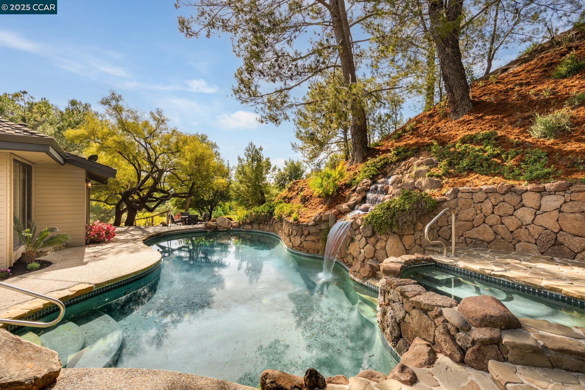 First time ever on the market, 2565 Rolling Hills Ct offers an extraordinary opportunity to own a custom residence in Alamo’s coveted Round Hill Country Club.  Designed for elevated everyday living and effortless entertaining, this exceptional home captures panoramic views and features seamless indoor-outdoor flow with dramatic walls of sliding glass doors that open to expansive patios, a solar-heated pool and spa, and the rolling hills beyond.  The main-level primary suite provides a private retreat with stunning outlooks, while an elevator from the garage to the main floor ensures comfort and accessibility for all stages of life.  A standout feature is the spacious second bedroom, which was thoughtfully designed with the potential to be easily converted into two separate bedrooms, offering flexibility for growing families, guests, or work-from-home needs.  With owned solar and a Tesla backup battery, this home is both energy-efficient and future-ready.   Set on a quiet court in one of Alamo’s most desirable neighborhoods, this is more than a home—it’s a legacy property in a premier country club setting.