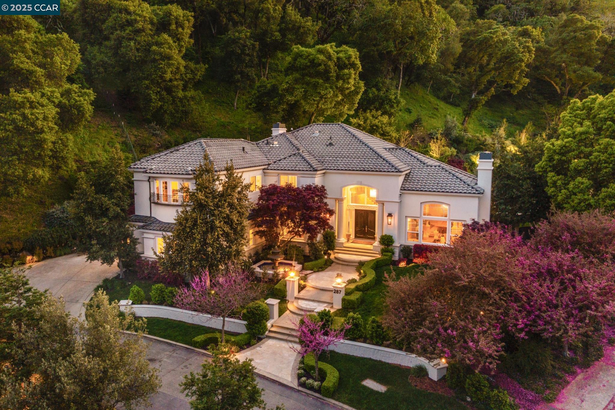 Nestled on one of Westside Alamo’s most coveted streets, this stunning estate is in the exclusive gated community of Lark Lane. Blending luxury, sophistication, and modern convenience, it sits on a sprawling property w/ a private vineyard. A grand entrance with manicured landscaping leads to exquisite interiors featuring rich hardwood floors, soaring ceilings, and designer Restoration Hardware lighting. The impressive foyer boasts a sweeping spiral staircase beneath a striking chandelier. Designed for refined entertaining, the home offers a formal living room with a fireplace, an elegant dining room, a chef’s kitchen w/ Taj Mahal quartzite countertops, custom cabinetry, a walk-in pantry, premium appliances, and farmhouse sink. The kitchen opens to a sunlit breakfast nook and an expansive family room. A media room with built-ins serves as a versatile retreat. Upstairs, the grand primary suite features a private balcony, custom walk-in closet, and spa-like bath. 3 junior suites, two additional bedrooms, and a second laundry room complete the level. The backyard is an entertainer’s dream, with a pool, sports court, putting green, playground, outdoor kitchen, and private vineyard views. Minutes from downtown Alamo and award-winning schools, this estate offers privacy and luxury.