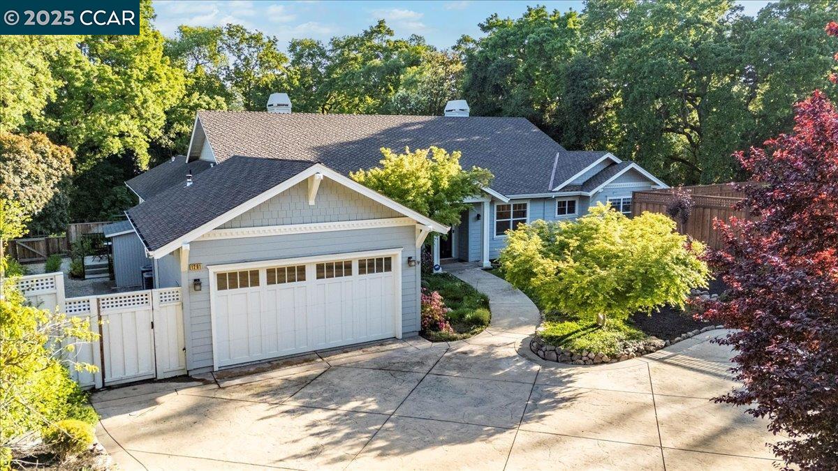 Tucked away down a private drive on an expansive lot, 1291 Clover Lane offers rare seclusion just a short walk from the heart of downtown Walnut Creek. This custom-built one story home combines timeless craftsmanship with modern comfort in the coveted Saranap neighborhood. Step inside to discover refined finishes including elegant crown moulding, custom built-ins, and spacious living areas filled with natural light. The gourmet kitchen is a chef’s dream—complete with a 6-burner stove, double oven, oversized granite island, pantry, and a bar with wine fridge—perfect for both entertaining and everyday living. The luxurious primary suite is its own retreat, featuring a cozy fireplace and an enormous walk-in closet with skylight. A full laundry room with sink, and thoughtful layout add comfort and convenience throughout the home. Ideal for extended family, guests, or rental income, the attached one-bedroom in-law unit includes a kitchenette and private entrance. Outside, the terraced backyard is an entertainer’s paradise, boasting a stone patio, built-in fireplace, and grill—all surrounded by serene landscaping and ultimate privacy. This is more than a home—it’s a lifestyle. Space, location, and custom touches all come together at 1291 Clover Lane.
